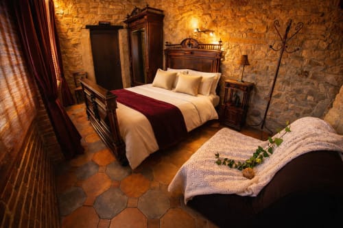 Dormitorio de piedra con iluminación cálida y rincón de descanso íntimo