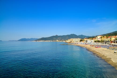 Spiaggia di Loano con acque turchesi, litorale sabbioso e edifici colorati affacciati sulla costa mediterranea