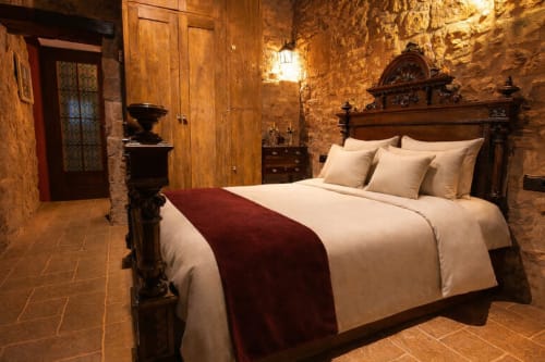 Dormitorio dúplex de piedra con mobiliario clásico y luz cálida