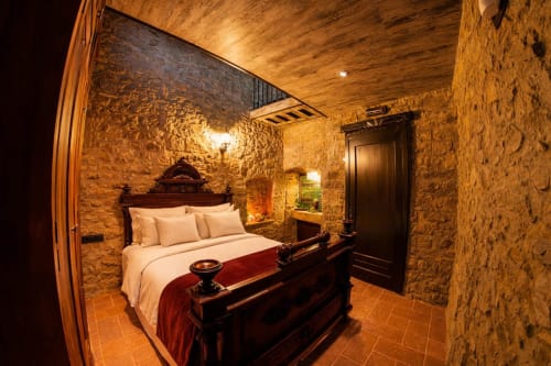 Dormitorio dúplex de piedra con iluminación cálida y mobiliario clásico