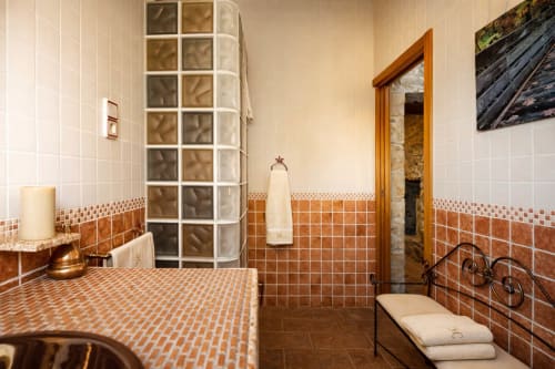 Baño luminoso con acabados cálidos y detalles de piedra