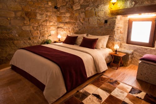 Dormitorio de piedra con luz cálida y ambiente acogedor