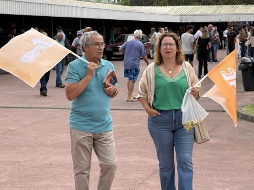 Two people holding flags at outdoor event near Golden Mermaid Villa in Ribeirinha, Portugal