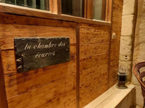 Portes d'écurie en bois avec panneau en ardoise « la chambre des écuries » à l'hôtel-boutique Les Troglos de Beaulieu en France