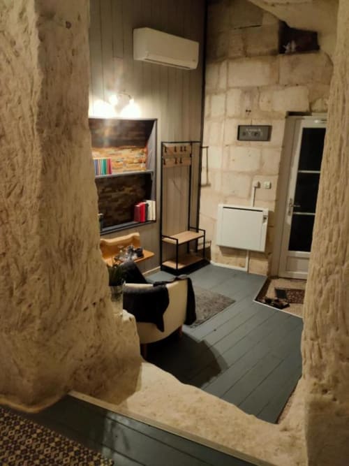 Cozy troglodyte room interior at Les Troglos de Beaulieu with stone walls, modern furnishings, and private entrance