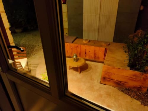 Chambre avec vue jardin Les Troglos de Beaulieu, mobilier en bois, table ronde et accès à terrasse privée