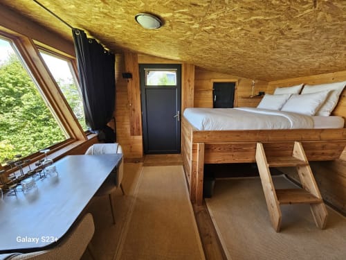 Chambre cosy dans une cabane en bois du Logis Las Crozas avec lit, bureau, vue sur la fenêtre et ambiance montagnarde à Vernines