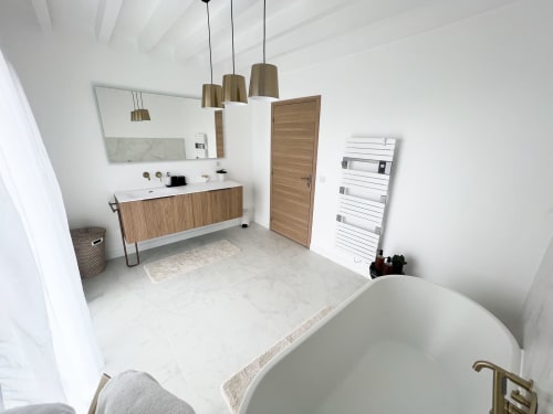 Salle de bain moderne de l'hôtel Anne Duval à Saint-Florent avec baignoire îlot, meuble-lavabo en bois et luminaires suspendus