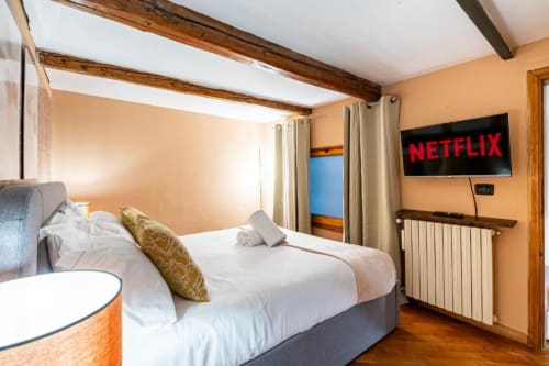Camera moderna a Bronze Horse Affittacamere a Firenze con letto a baldacchino, TV Netflix, travi in legno e pareti color pesca