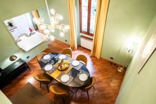Elegante sala da pranzo presso il Bronze Horse Firenze B&B con tavolo preparato, moderne lampade a sospensione e pareti verdi