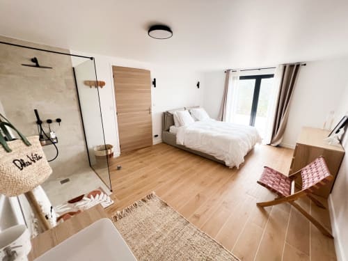 Chambre moderne de l'hôtel Anne Duval à Saint-Florent avec parquet, salle de bain attenante et accès au jardin