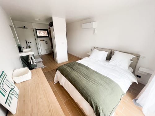 Chambre moderne de l'hôtel Anne Duval à Saint-Florent avec lit queen-size, salle de bain attenante et parquet