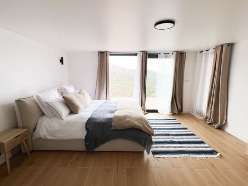 Chambre spacieuse et moderne à l'hôtel Anne Duval à Saint-Florent avec grand lit, parquet et portes coulissantes donnant sur