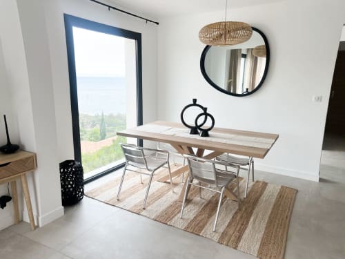 Salle à manger moderne de l'hôtel Anne Duval à Saint-Florent avec vue sur mer, table en bois et décoration contemporaine