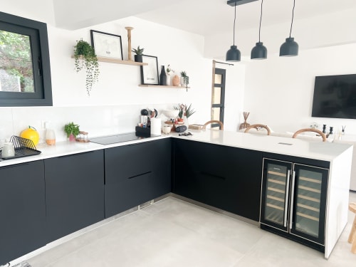 Cuisine moderne en noir et blanc à l'hôtel Anne Duval à Saint-Florent avec luminaires suspendus, plans de travail blancs et étagères ouvertes