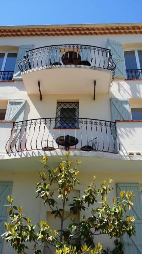 Façade élégante de l'immeuble méditerranéen de la Résidence Kimi à Cannes avec balcons courbes, volets bleu clair