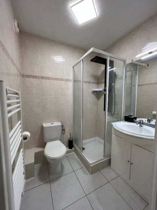 Salle de bains moderne de la Chambre Double Standard à Kimi Résidence, Cannes, avec douche, toilettes, lavabo et radiateur sèche-serviettes