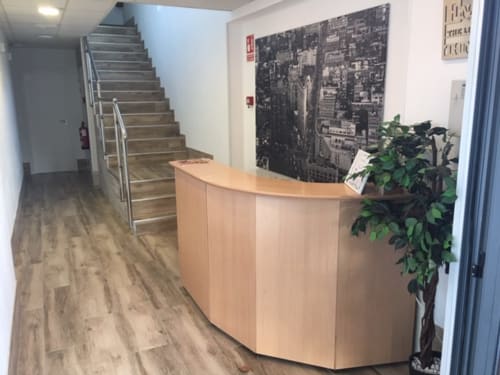 H Skyline hotel reception desk in Alcorcón, Madrid with wooden counter, plant, and stairs