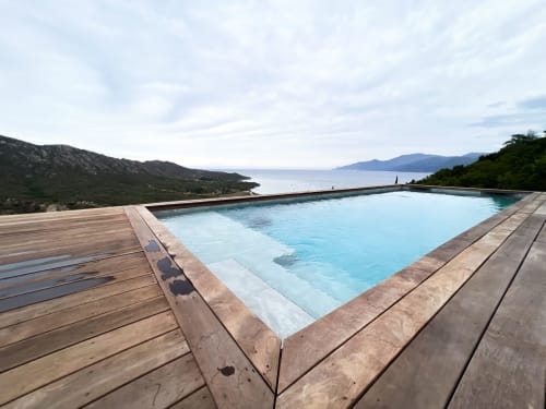 Piscine à débordement avec terrasse en bois vue sur la mer Méditerranée et les montagnes, hôtel Anne Duval, Saint-Florent