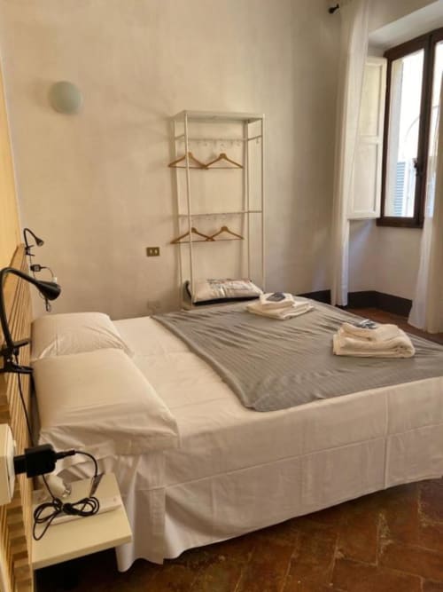 Ampia camera da letto presso Bronze Horse Affittacamere a Firenze con letto matrimoniale, armadio e finestre