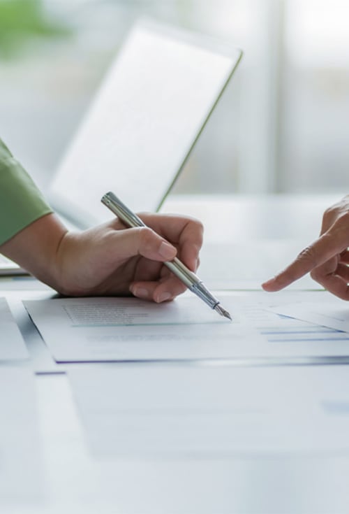 Persona che firma un documento presso l'hotel AmazHome a Rimini durante il check-in o la sottoscrizione di accordi