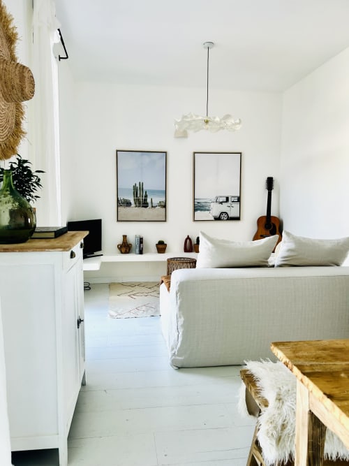 Bright bedroom in Casa di Bastia apartment with bed, acoustic guitar, framed coastal art, white walls, and sea view in