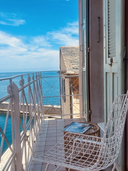 Seaside balcony at Casa di Bastia, Bastia apartment with sea view, modern lounge chairs overlooking turquoise Mediterranean
