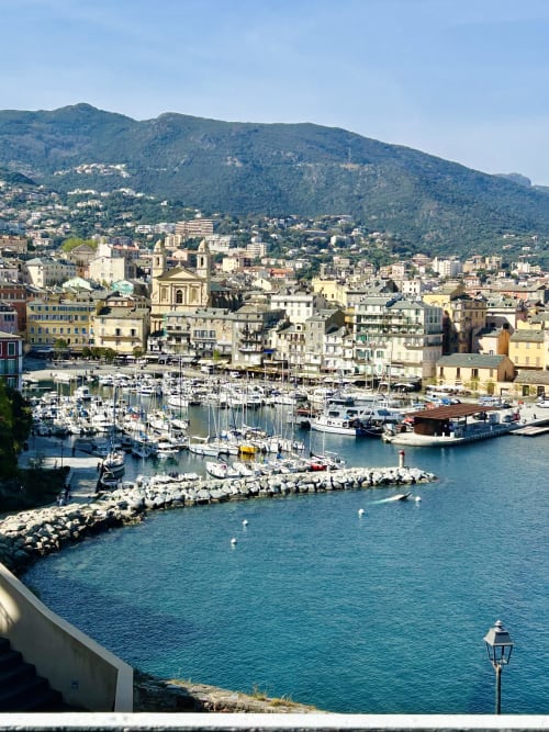 Bastia harbor with sailboats, colorful buildings, and green mountains - Casa di Bastia sea view apartment