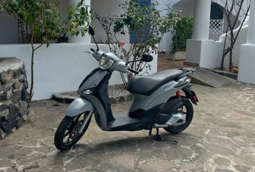 Scooter grigio e nero parcheggiato nella corte di Le sette perle, Malfa, Sicilia