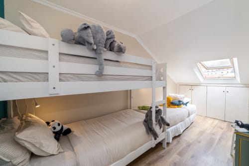Apartamento moderno com 2 quartos na Bica Mini Hostel em Lisboa, com camas beliche brancas, claraboias e armazenamento.