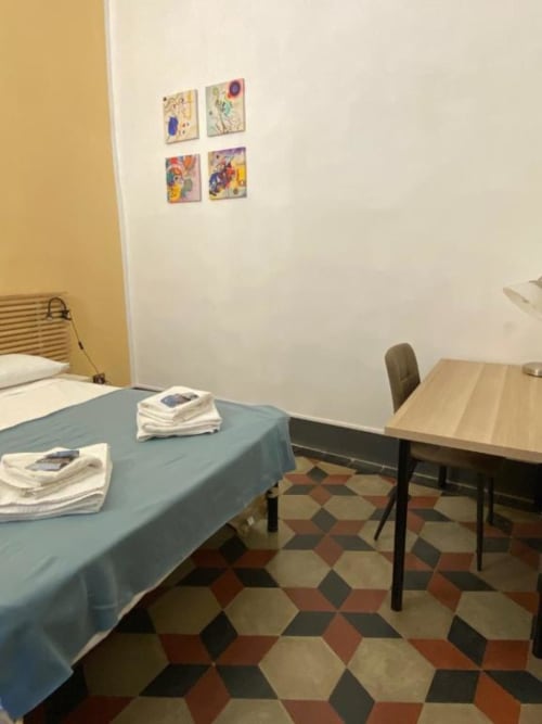 Camera degli ospiti presso Bronze Horse Affittacamere a Firenze con letto, scrivania e coloratissimi dipinti murali