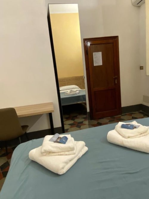 Camera d'hotel al Bronze Horse Affittacamere di Firenze con letti gemelli, asciugamani freschi e specchio a figura intera