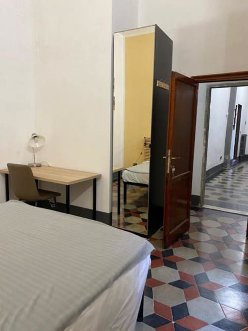 Camera spaziosa presso il Bronze Horse Affittacamere a Firenze con letto, scrivania e pavimento in piastrelle colorate