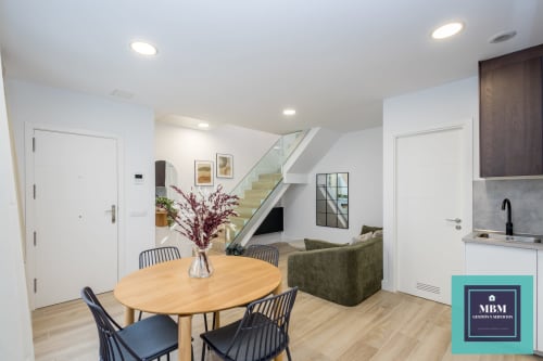 Moderno apartamento dúplex en MBM Hostel de Arucas con comedor, cocina, sala y escalera de acceso a loft