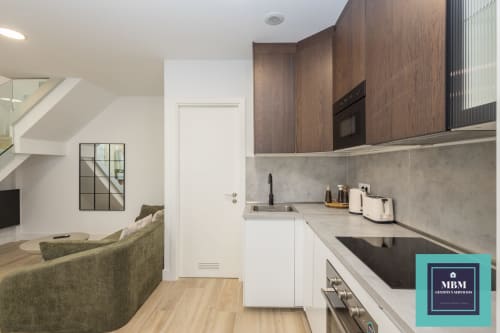 Cocina y sala de estar modernas en apartamento Dúplex Albareda del hostel MBM, Arucas Las Palmas, con mueblería de madera y vistas ciudad
