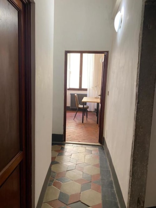 Hallway at Bronze Horse Affittacamere in Florence leading to bedroom with terracotta tiles