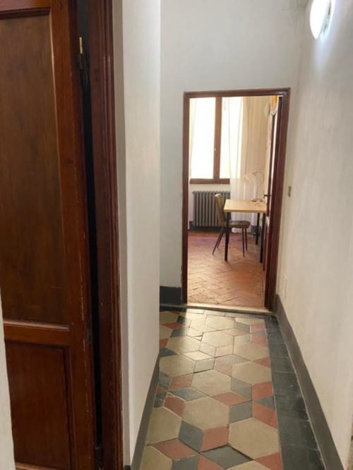 Hallway entrance to guest room at Bronze Horse Affittacamere Firenze, Florence, with wooden doors and geometric tile flooring