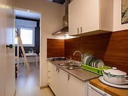 Modern kitchen in Monolocale 2 apartment at Il Maestrale B&B in Padova, with wooden cabinets and dishware