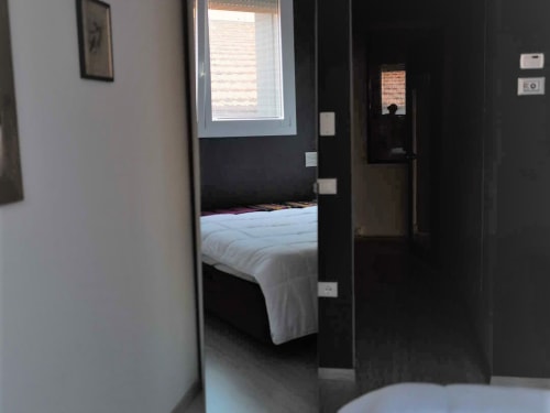 Camera da letto presso Il Maestrale B&B a Padova con biancheria bianca, pareti scure e finestra