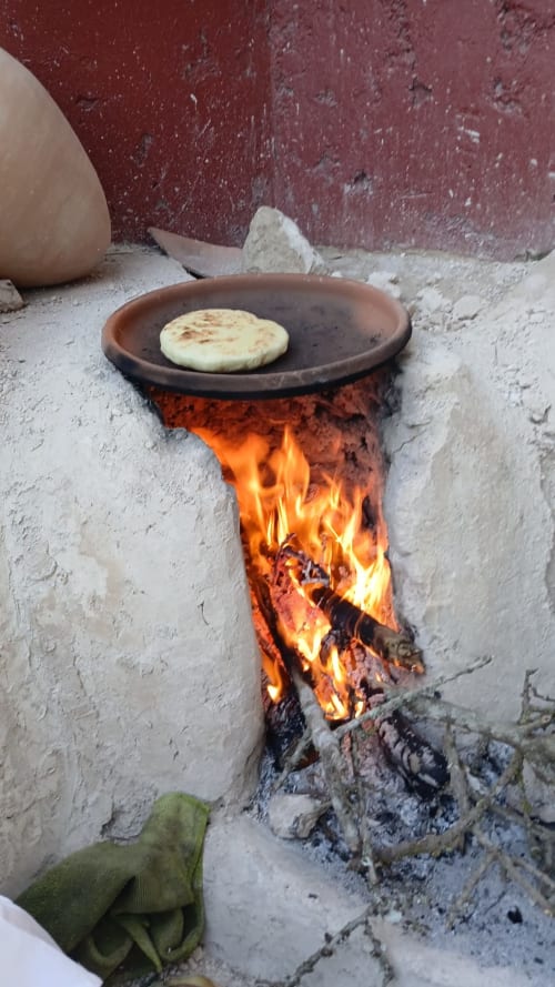 Préparation traditionnelle de pain plat sur feu ouvert au Riad Eucalyptus, hôtel ethnique à El Ghazouane, Maroc