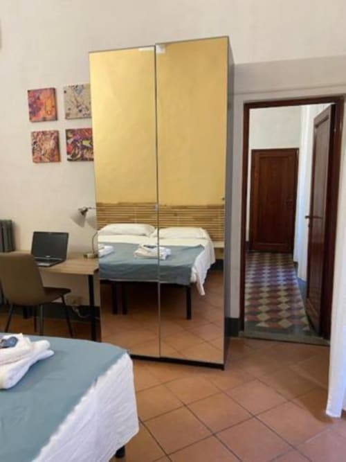 Habitación moderna en Bronze Horse Affittacamere en Florencia con armario espejo, cama, escritorio y arte mural colorido