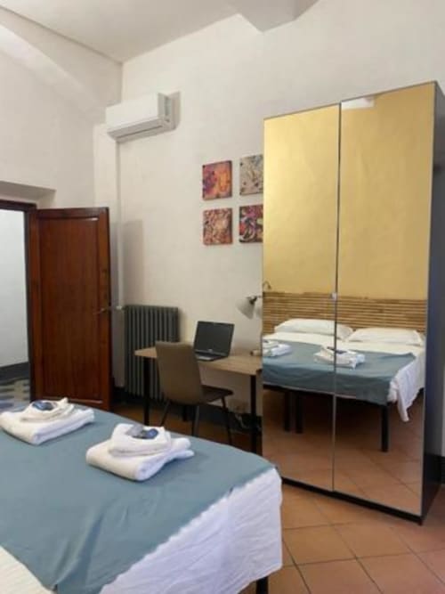 Habitación moderna para huéspedes en Bronze Horse Affittacamere en Florencia con armario espejo, escritorio y camas gemelas