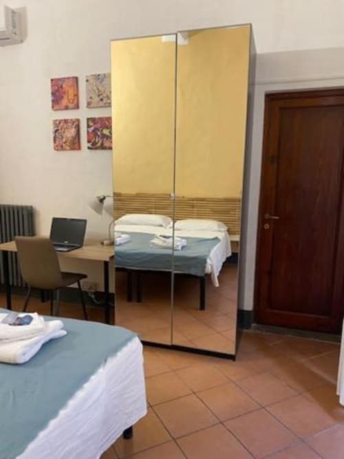Habitación moderna en Bronze Horse Affittacamere de Florencia con armario espejado, camas y escritorio
