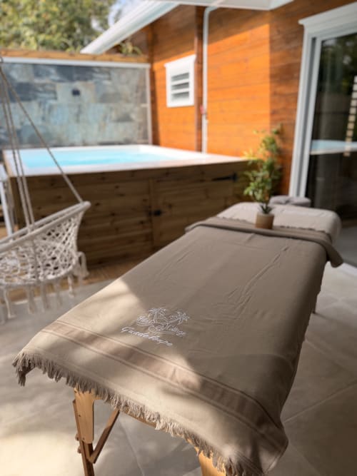 Spa massage bed with towel at Filao Cottage, a Guadeloupe BnB in Sainte-Rose, with hot tub and orange bungalow