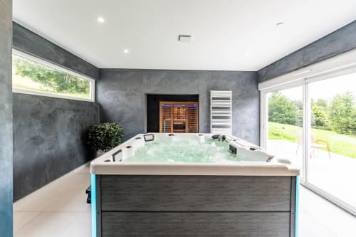 Spa moderne du Refuge des Brumes avec bain à remous, sauna et vue sur le jardin en France