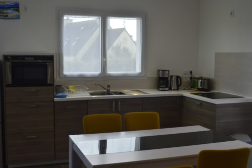 Cuisine moderne et coin repas à la Résidence des dunes, Landéda, avec kitchenette équipée et vue sur le jardin