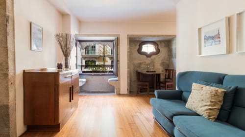 Salon moderne de l'appartement de Porto avec canapé bleu, parquets en bois et accès au balcon à Flowerstreet54