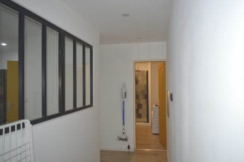Couloir moderne de la Résidence des dunes avec cloison vitrée à cadre noir et porte en bois, Landéda