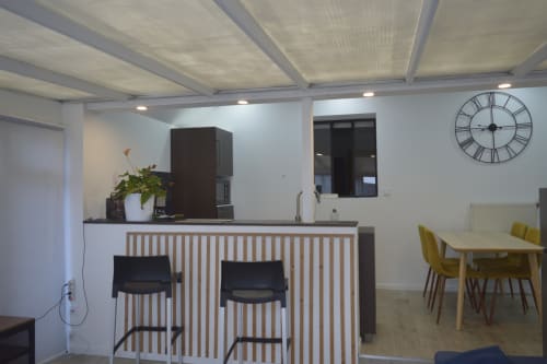 Cuisine moderne et salle à manger à la Résidence des dunes avec îlot central et horloge romaine