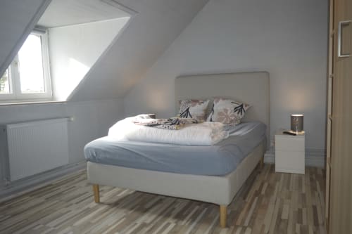 Chambre mansardée lumineuse à la Résidence des dunes avec lit crème, fenêtre de toit et parquet à Landéda